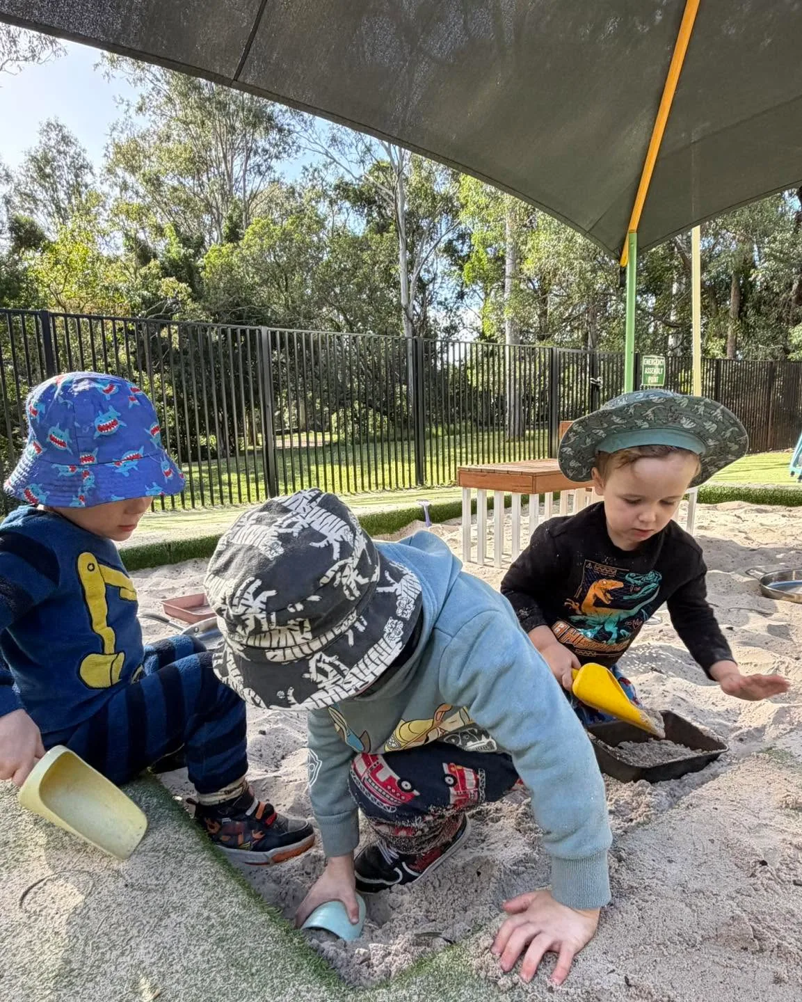 Three toddlers digging in the sandpit at Cherubs Nerang