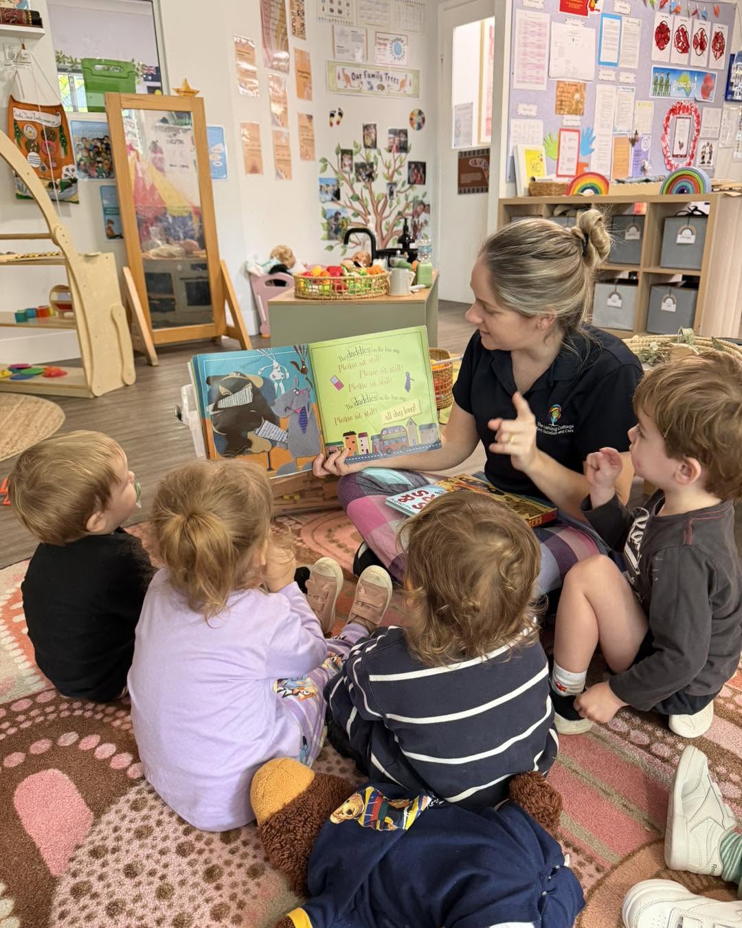 An Educator reading a picture book to a group of toddlers at Cherubs Nerang
